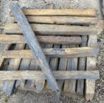 Piquets de schiste de différentes hauteurs intégrés dans un aménagement paysager avec graviers décoratifs.