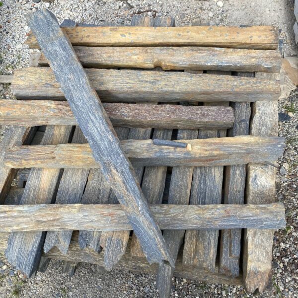 Piquets de schiste de différentes hauteurs intégrés dans un aménagement paysager avec graviers décoratifs.