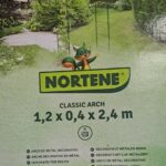 Arche de jardin décorative en métal vert pour plantes grimpantes installée dans une allée extérieure.