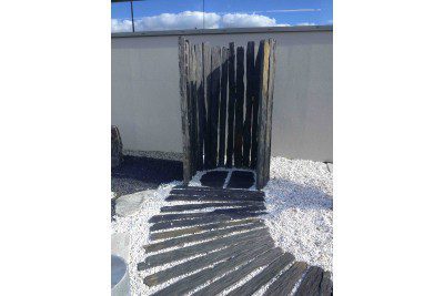 Piquet de schiste ardoisier naturel utilisé comme élément décoratif dans un aménagement paysager de jardin.
