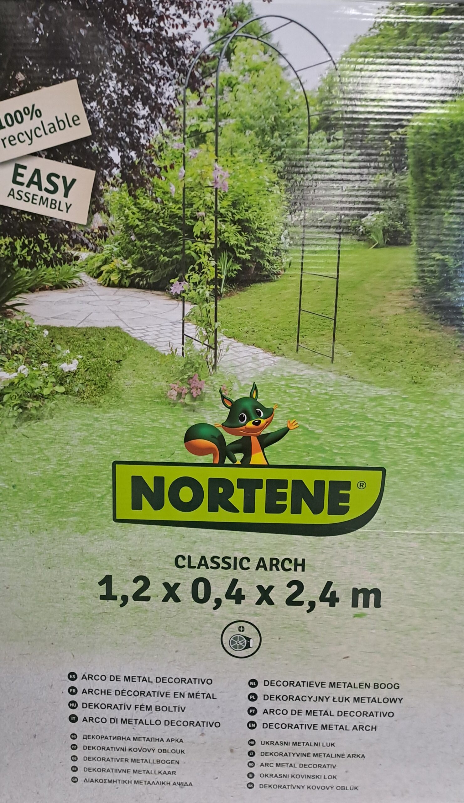 Arche métallique décorative charcoal pour jardin Arche de jardin décorative en métal couleur charbon, installée sur une allée, support pour plantes grimpantes.