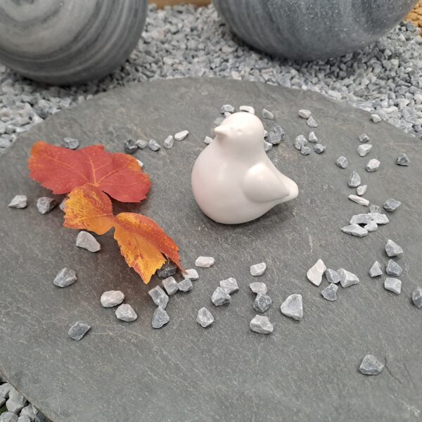 Oiseau décoratif en céramique blanche de petite taille pour décoration intérieure ou extérieure.