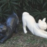 Statuette de chat assis au design épuré et géométrique, avec une finition effet terrazzo moucheté gris, noir et blanc.