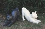 Statuette de chat assis au design épuré et géométrique, avec une finition effet terrazzo moucheté gris, noir et blanc.