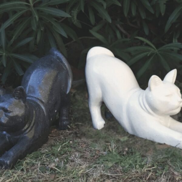 Statuette de chat assis au design épuré et géométrique, avec une finition effet terrazzo moucheté gris, noir et blanc.