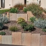Palis en grès multicolore naturel utilisé pour structurer un jardin et créer un aménagement paysager décoratif.